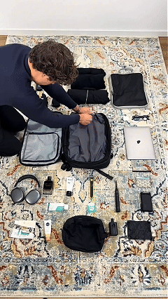 A customer packing the Max Travel Backpack